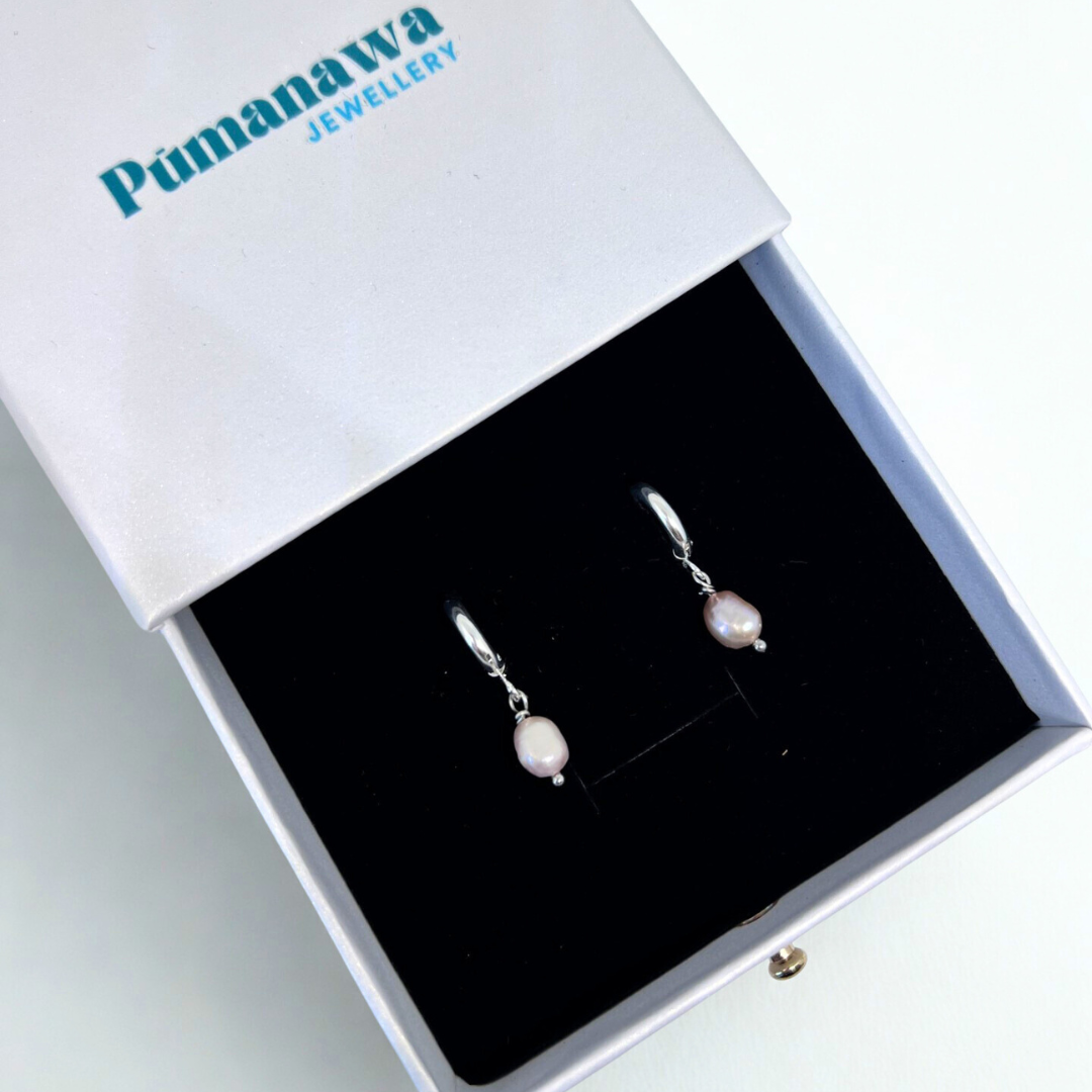 Pair of pearl earrings in a Pumanawa Jewellery box on a white background