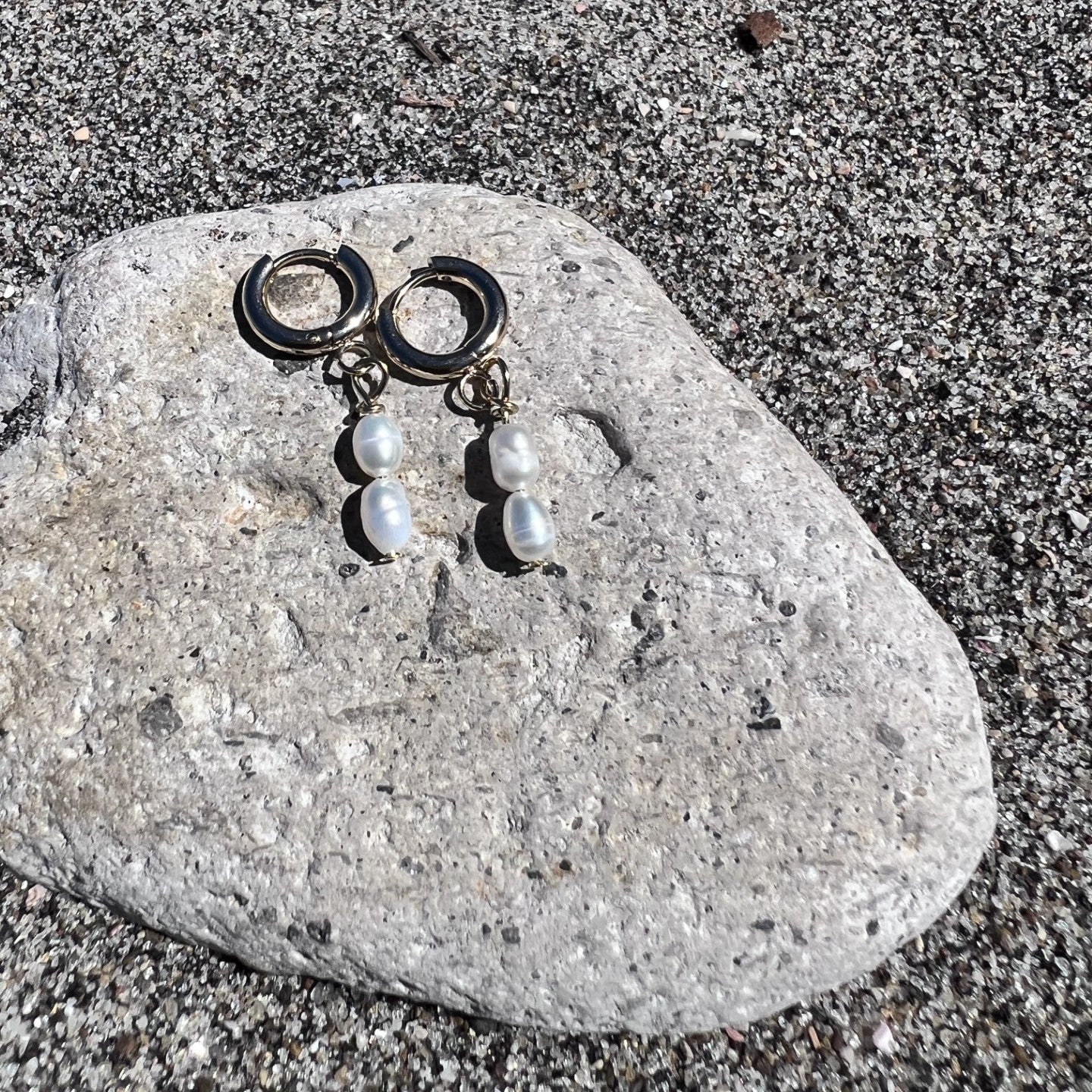 Pair of earrings with beads on a stone surface