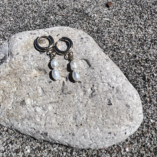 Pair of earrings with beads on a stone surface